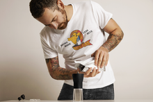 Load image into Gallery viewer, Classic Logo Tee - Barking Dog Roasters Man Pouring coffee into hand grinder wearing white Logo tee
